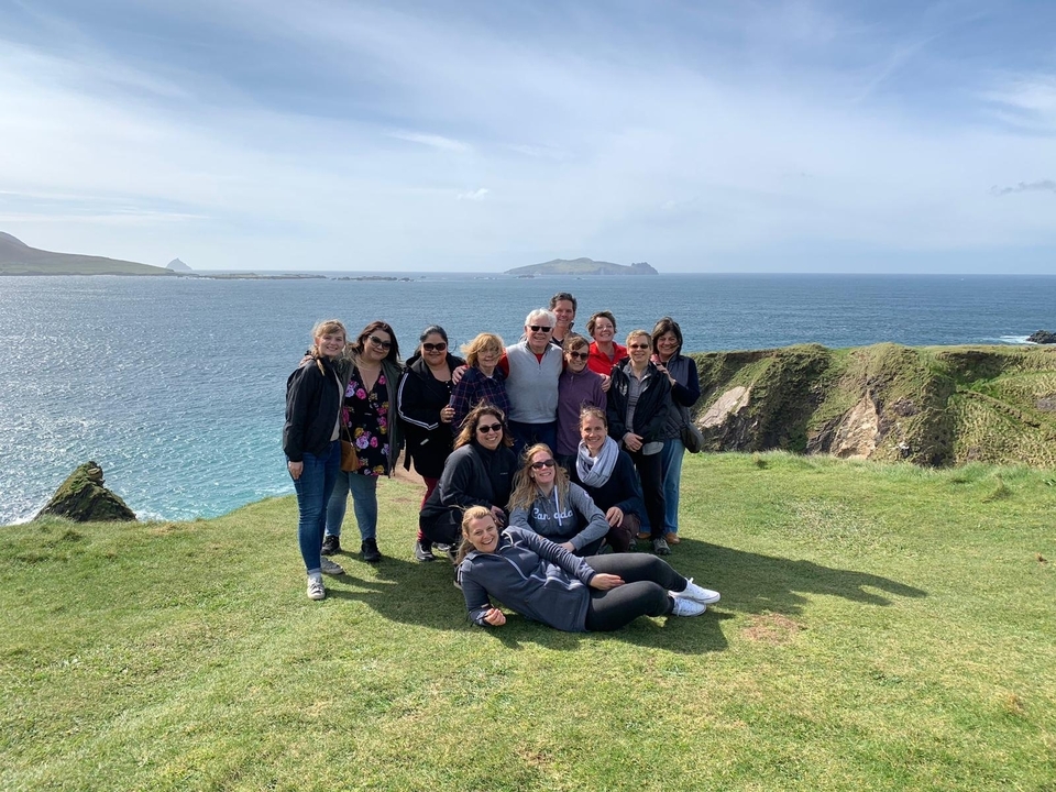 Groupe de personnes posant avec une vue panoramique sur l'océan en arrière-plan.
