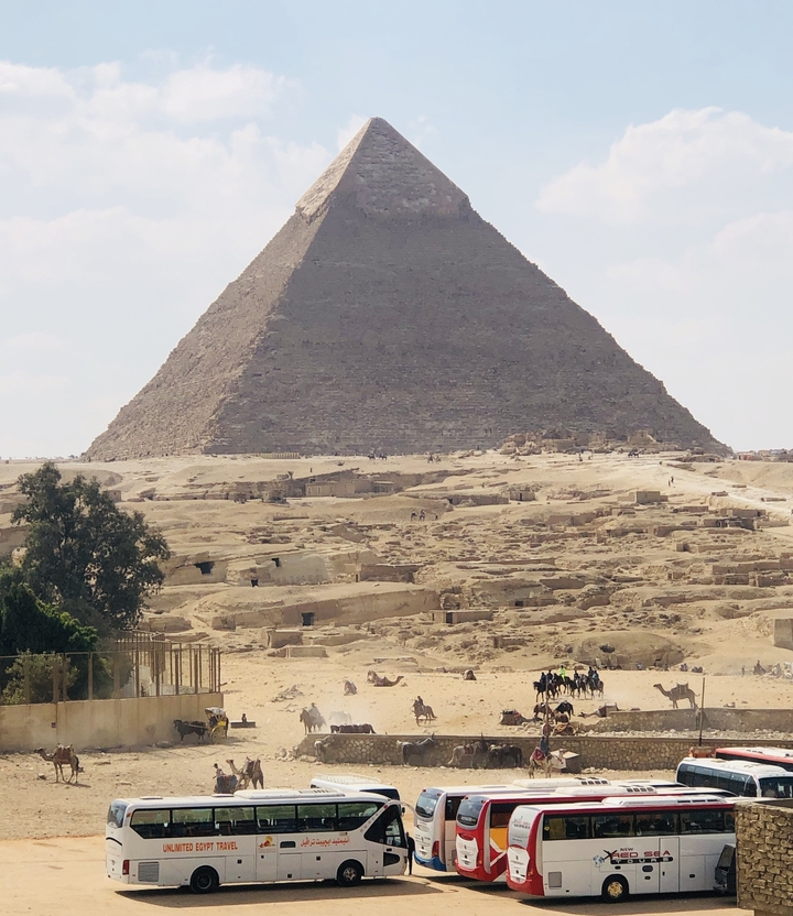 Une pyramide avec un paysage désertique au premier plan.