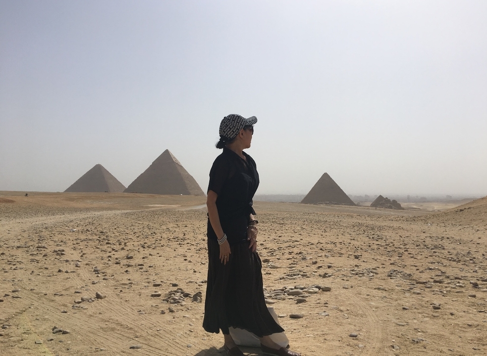 Personne debout devant les pyramides dans le désert.