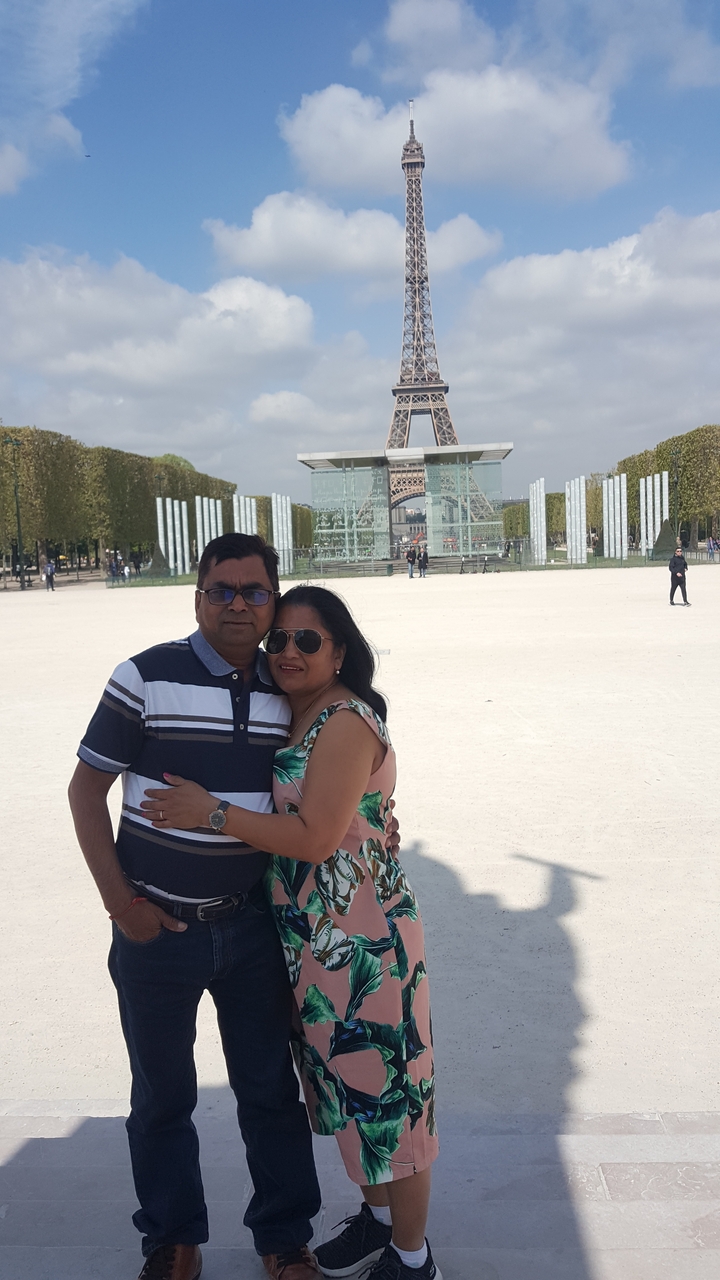 Couple posant devant la Tour Eiffel.