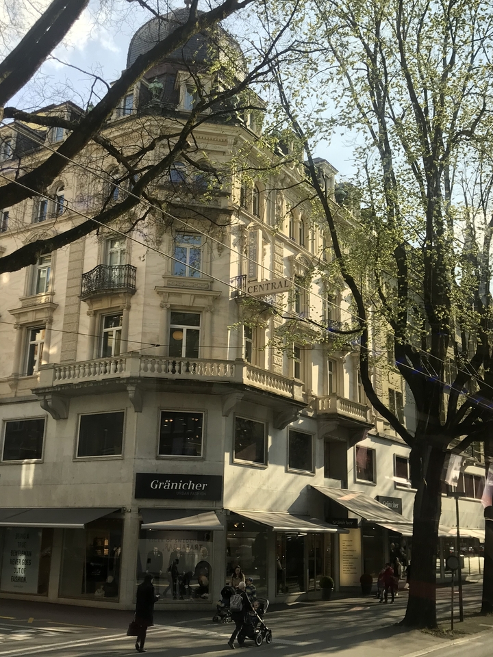 Bâtiment avec un panneau « Central » et des arbres bourgeonnants autour.