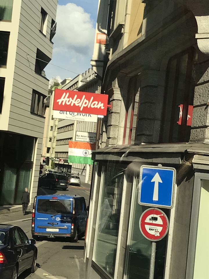 Vue de rue avec drapeaux et un panneau.