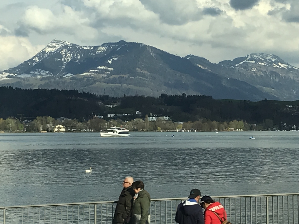 Au bord du lac avec des gens et des montagnes en arrière-plan.