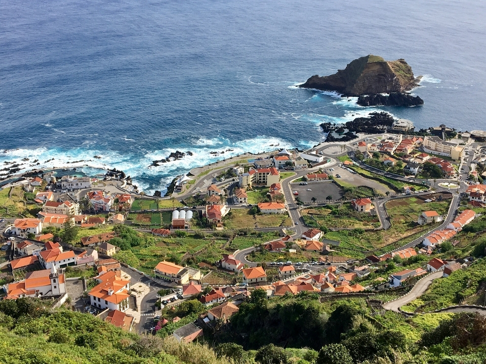 Vue aérienne d'une ville côtière avec une île au large.