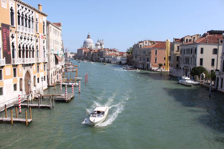 View of Grand Canal in Venice with a boat moving through.
