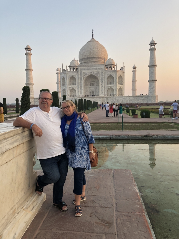 Couple debout devant le Taj Mahal.