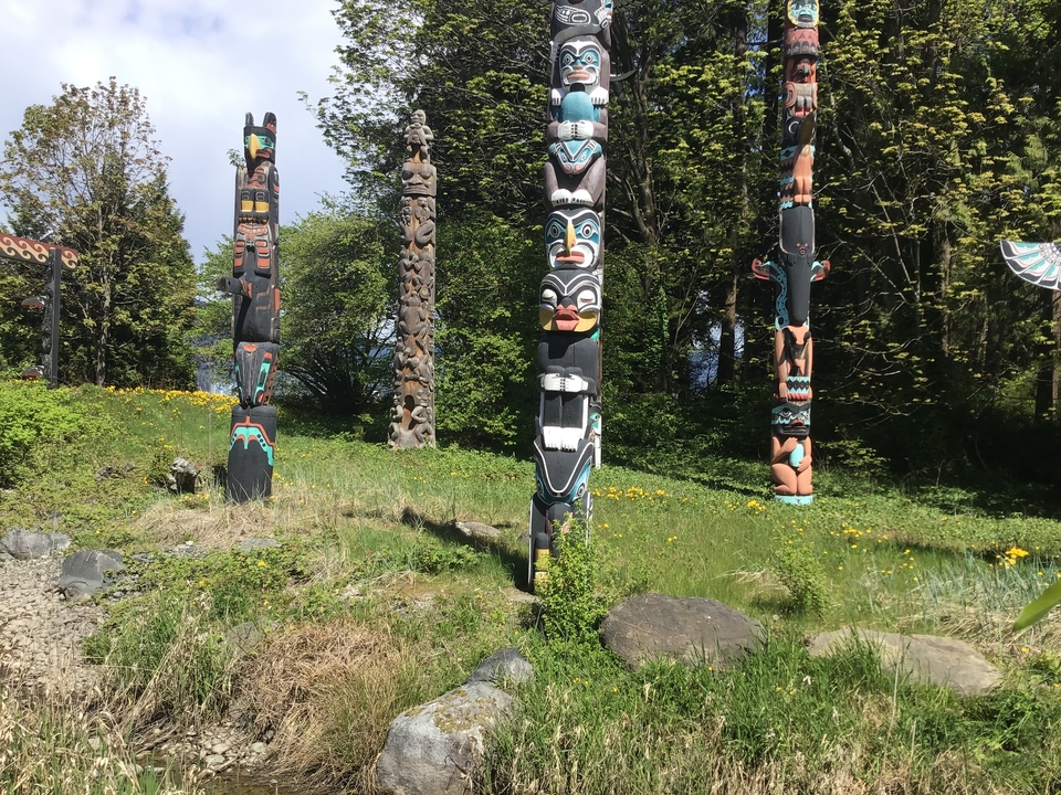 Totems dans une zone herbeuse entourée d'arbres.
