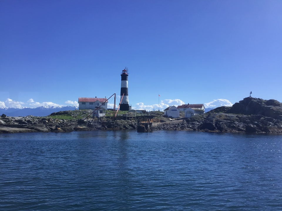 Phare historique et bâtiments sur une île rocheuse.