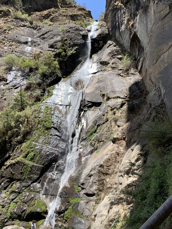 Cascade dévalant une montagne rocheuse.