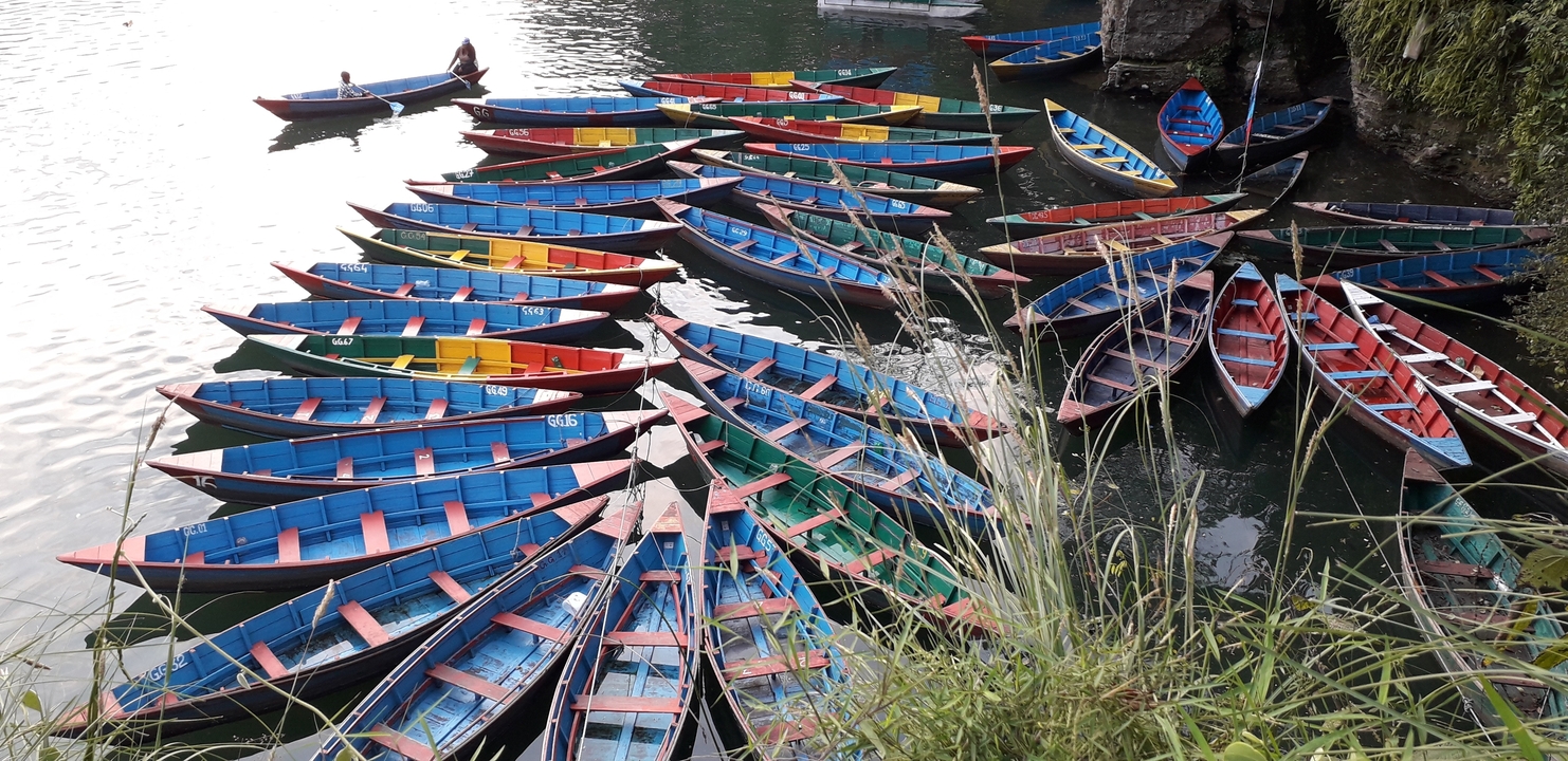 Des bateaux colorés disposés selon un motif sur l'eau.