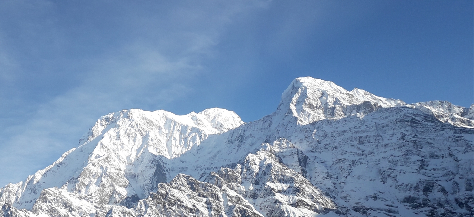 Des pics enneigés brillants sous un ciel bleu clair.