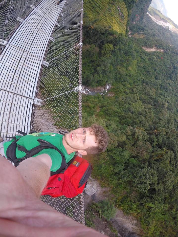 Personne prenant un selfie sur un pont suspendu.