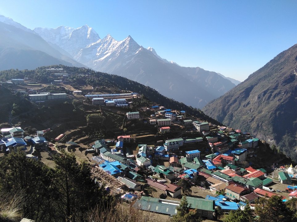 Village coloré niché dans les montagnes avec une vue dégagée sur les sommets.
