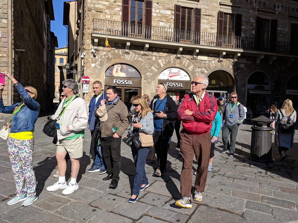 Un groupe de touristes explorant une rue de la ville avec des magasins.