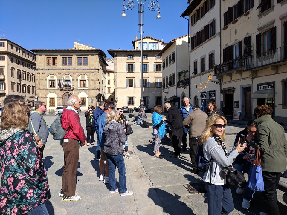 Des touristes se rassemblent sur une place de ville italienne.