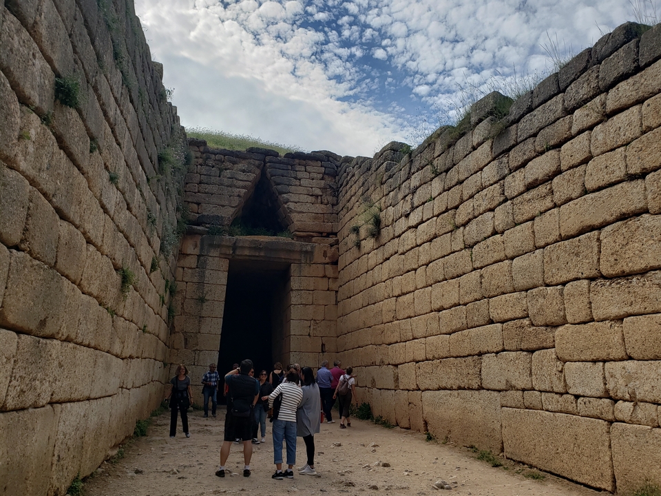 Des visiteurs à l'entrée d'une structure historique en pierre.