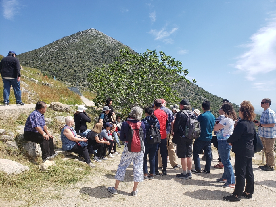 Groupe de touristes assis dans un paysage accidenté.