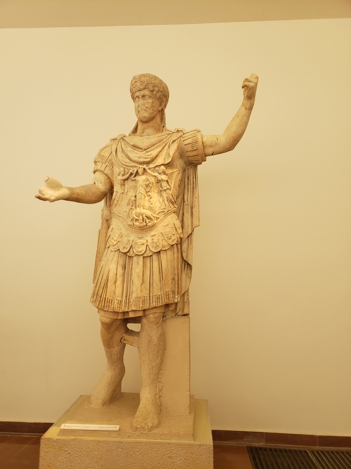 Une statue antique d'un soldat dans un musée.