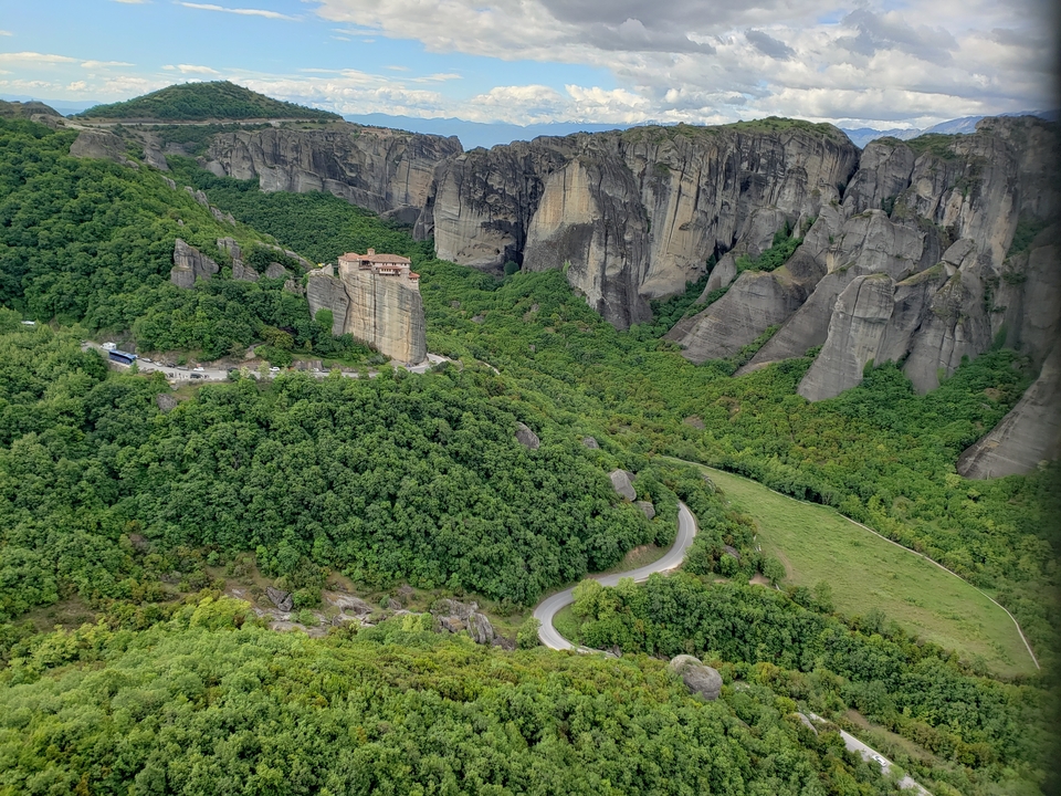 Monastère construit sur une formation rocheuse au milieu d'une végétation luxuriante.