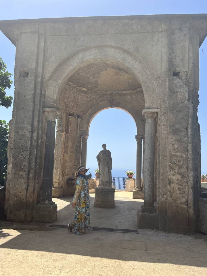Personne marchant sous des arches historiques.