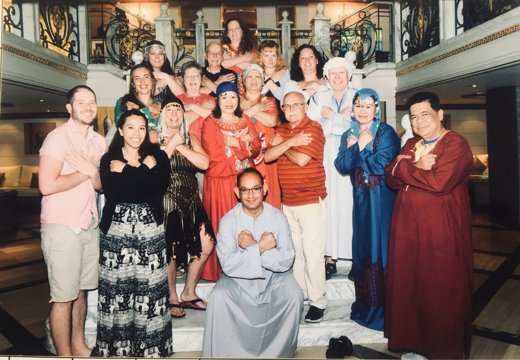 Groupe de personnes en tenue traditionnelle posant pour une photo.