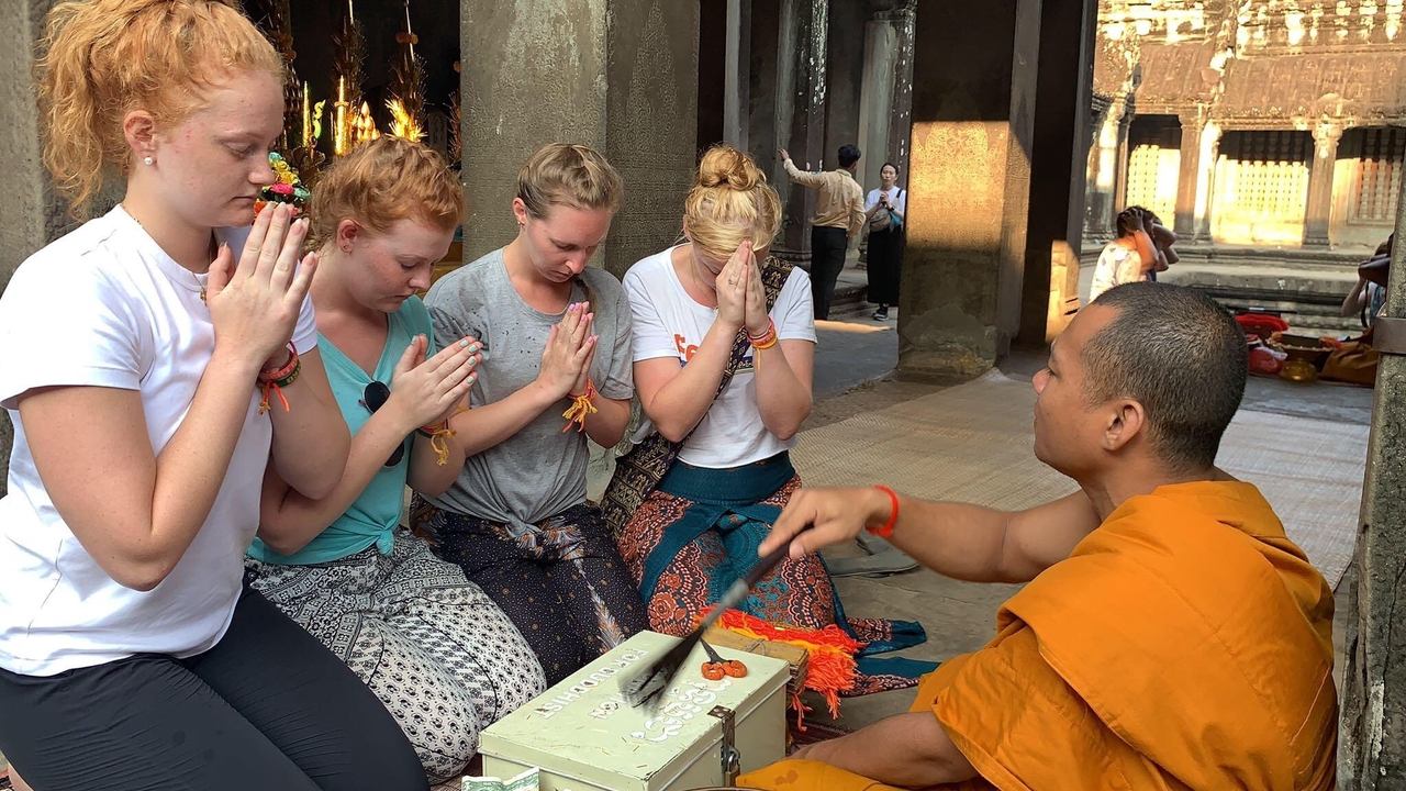 Groupe de femmes participant à une activité culturelle avec un moine.