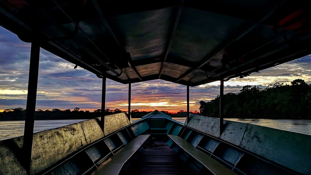 Vue du coucher de soleil depuis l'intérieur d'un bateau sur la rivière.