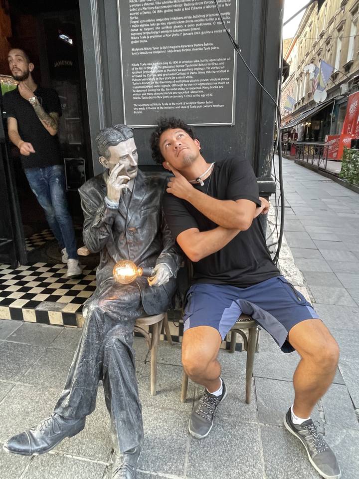 Homme assis avec une statue tenant une ampoule.