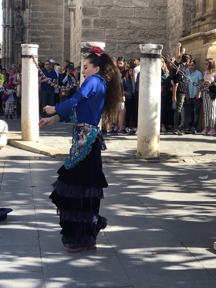 Danseuse de flamenco se produisant en plein air devant une foule qui regarde.