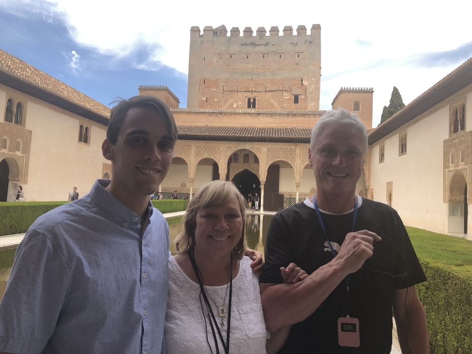 Trois personnes posant devant un palais historique.
