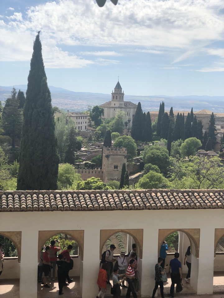 Jardins luxuriants dans un site historique avec des montagnes en arrière-plan.