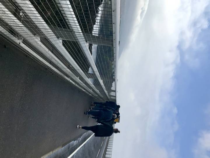 Groupe de personnes marchant sur un pont surplombant l'eau.