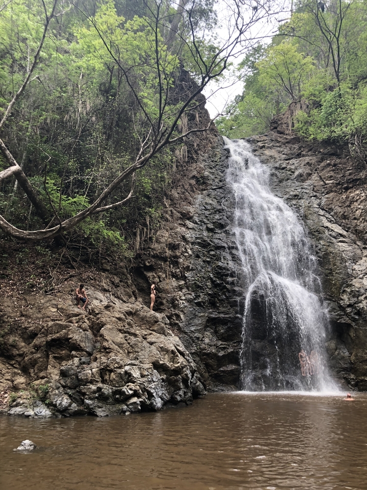 Deux personnes debout près d'une grande cascade.