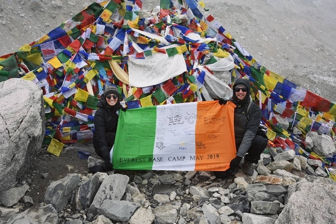 Deux personnes tenant un drapeau irlandais au camp de base.