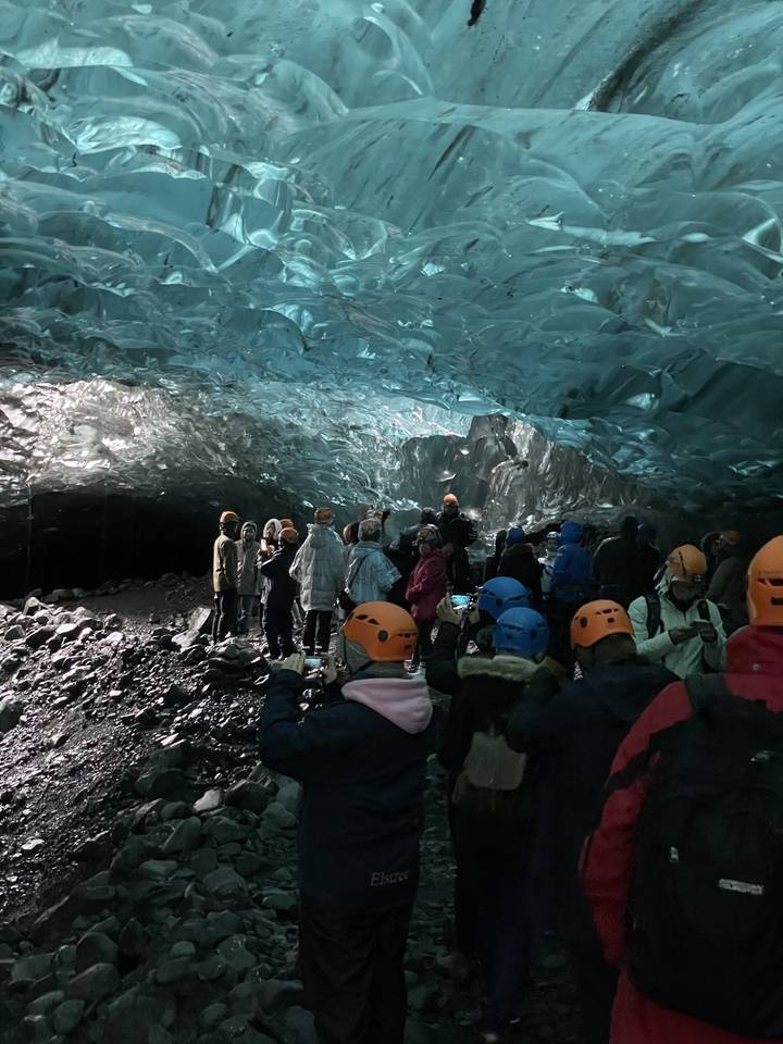 Groupe de personnes explorant l'intérieur d'une grotte de glace.