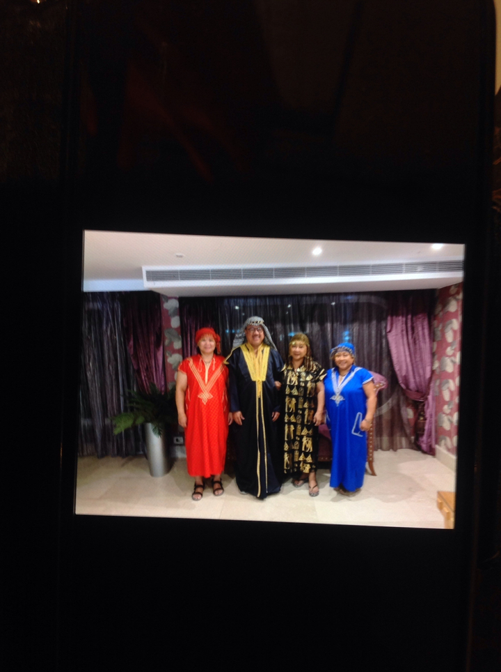 Groupe de personnes en costumes traditionnels posant à l'intérieur.
