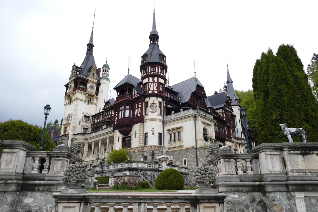 Château orné avec plusieurs tours et de la verdure.