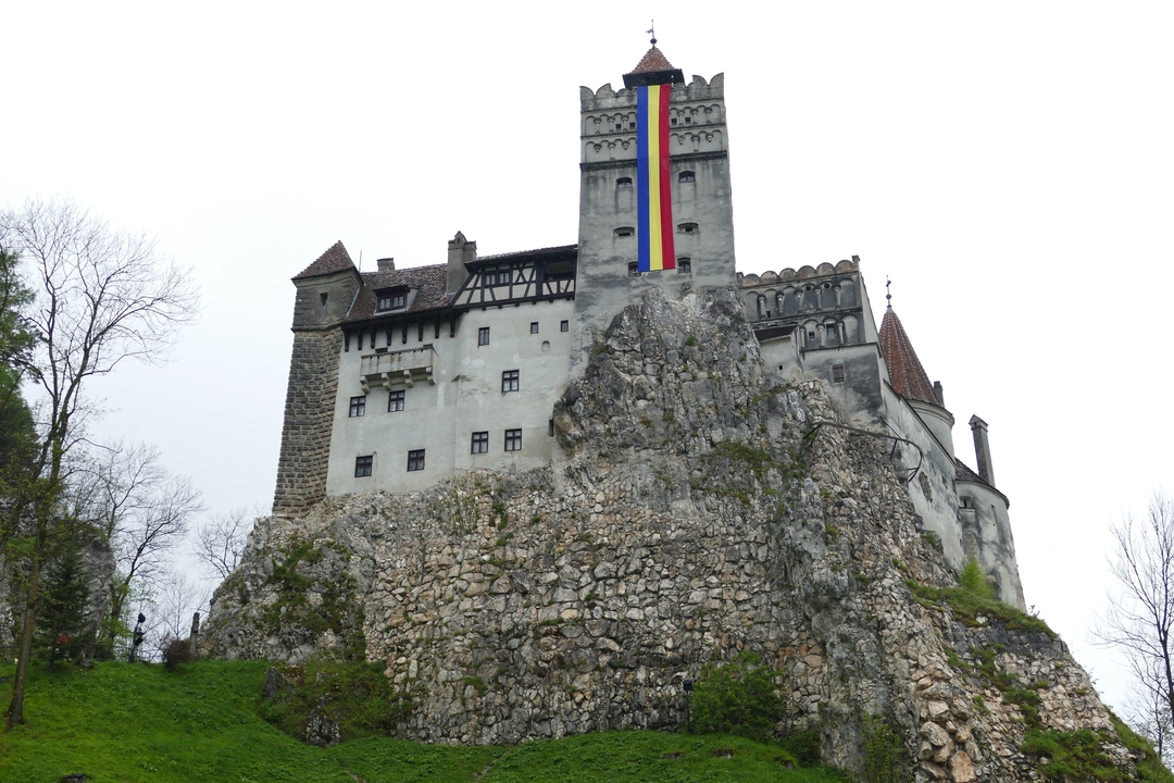 Château sur une colline rocheuse avec un grand drapeau.