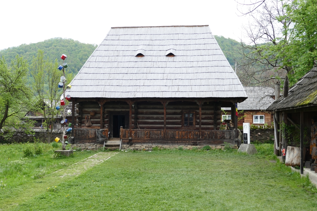 Maison traditionnelle en bois entourée de verdure.