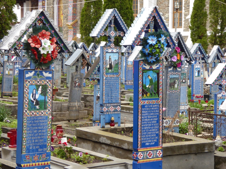 Tombes colorées aux motifs complexes, faisant partie d'un cimetière.