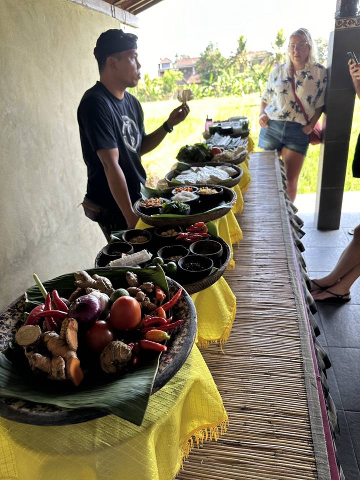 People sitting at a long table with various ingredients displayed.