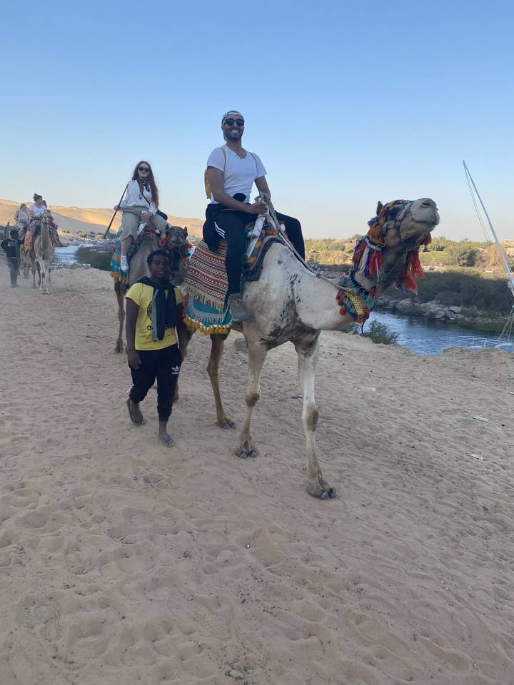 Des gens qui montent des chameaux dans un décor désertique.