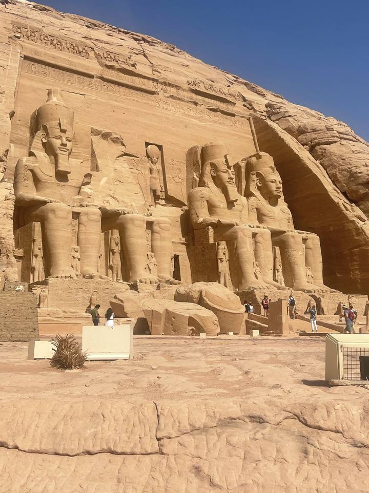 Statues de l'Égypte ancienne sculptées dans un temple de pierre massif.