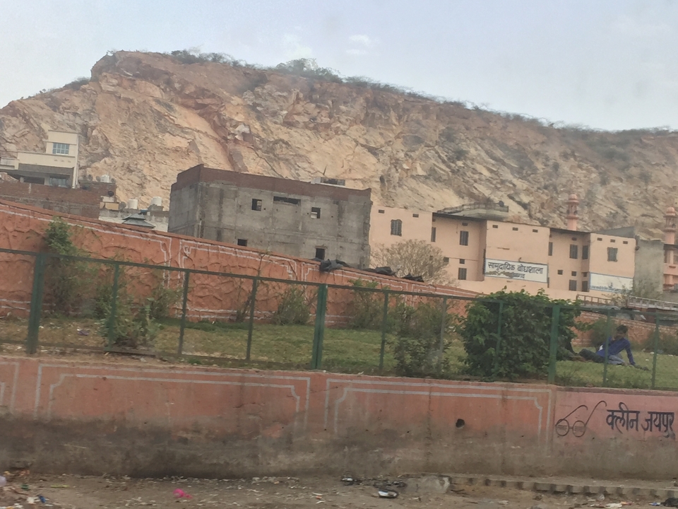 Scène urbaine avec des bâtiments à côté d'une colline rocheuse.