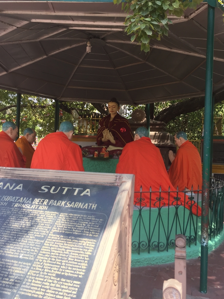 Des gens qui méditent avec une statue au centre.