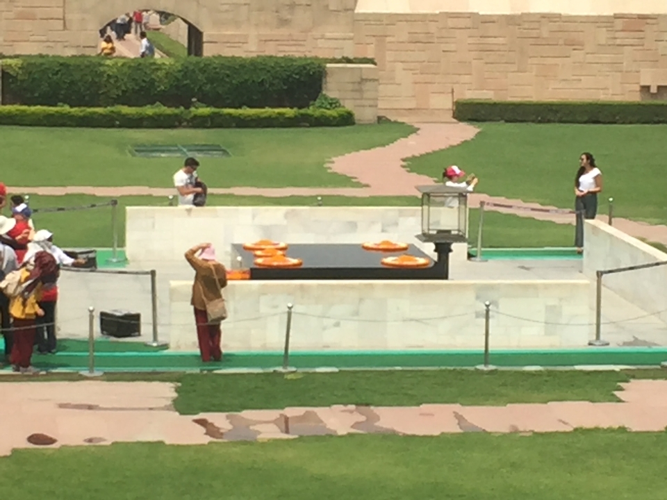 Des gens dans un parc avec un monument en béton.