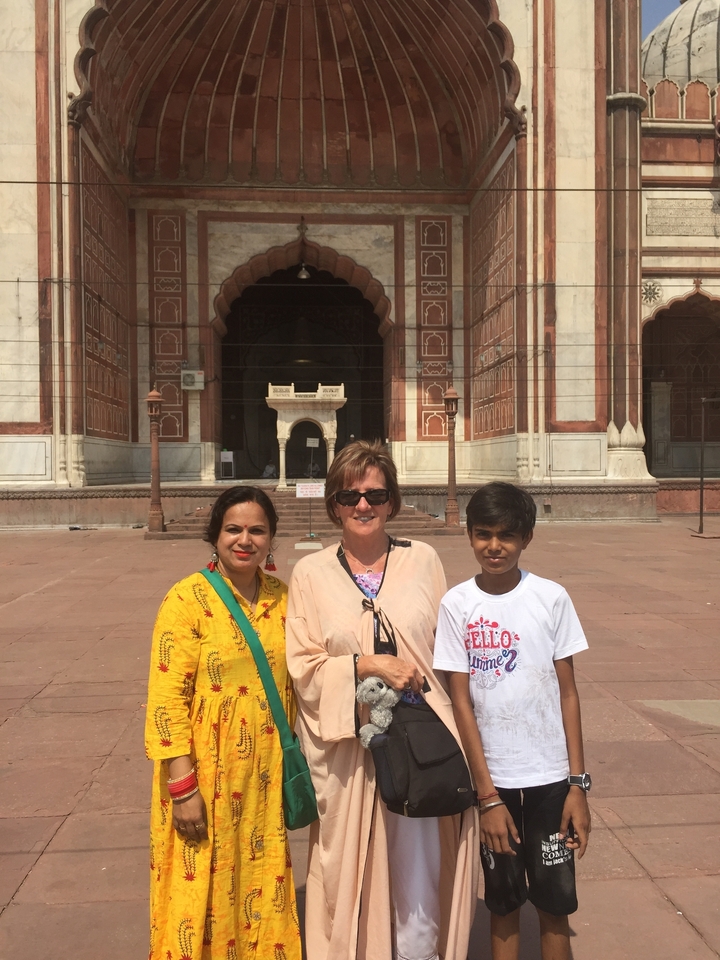 Trois personnes posant devant un bâtiment historique.