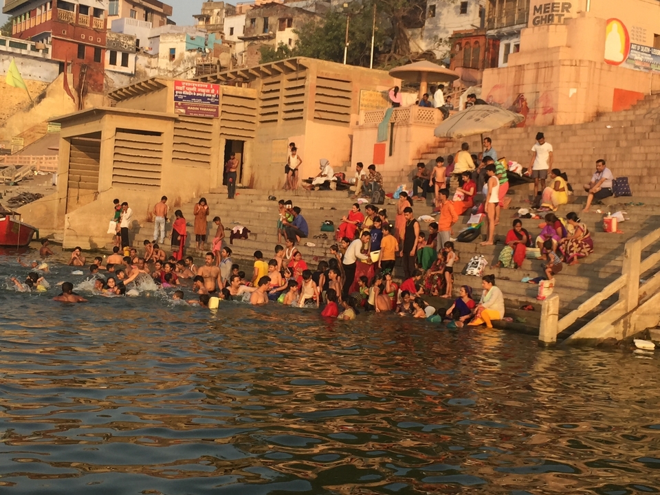 Une berge de rivière bondée avec des gens pratiquant diverses activités.
