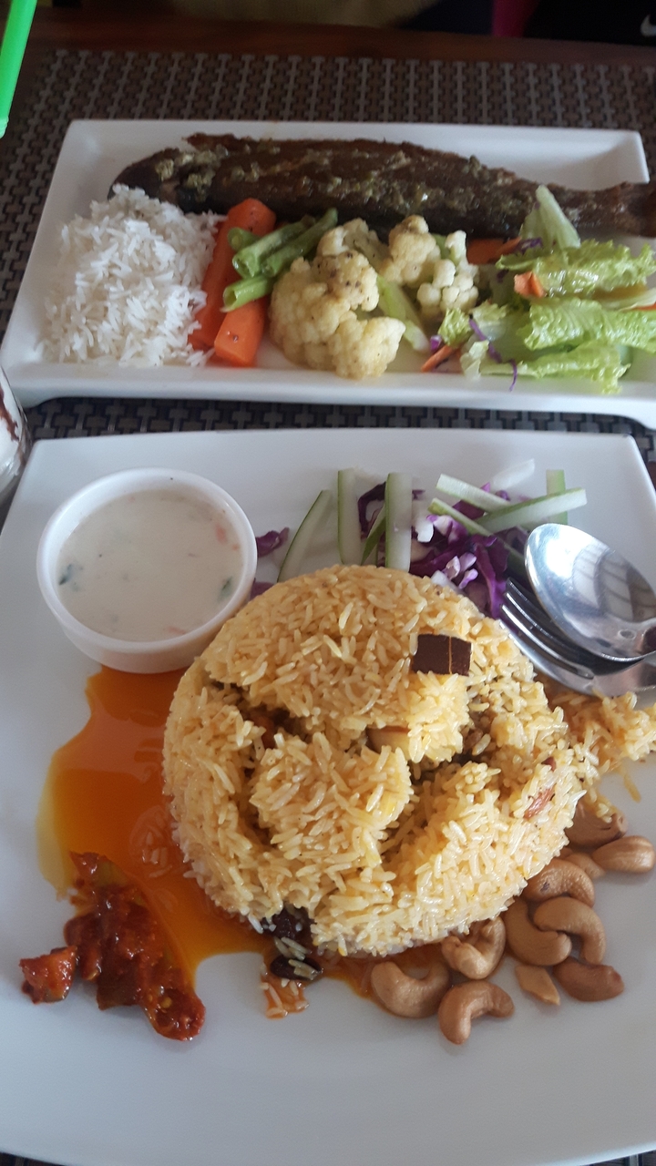 Une assiette de riz avec de la sauce et des légumes.