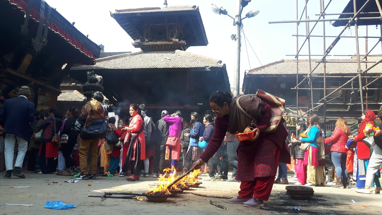 Foule dans un temple avec de l'encens qui brûle.